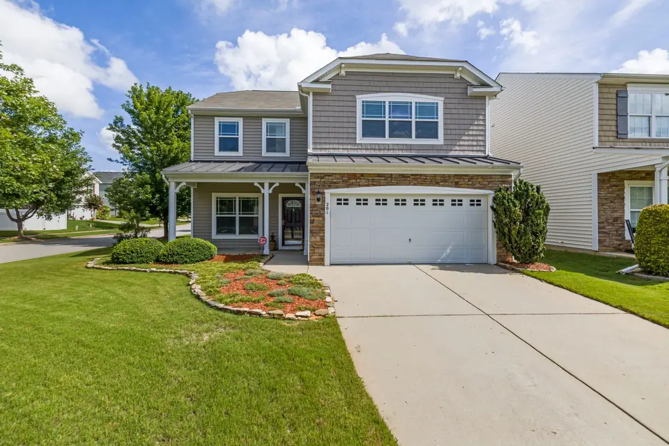 Two-story home with a neat front lawn and flower bed