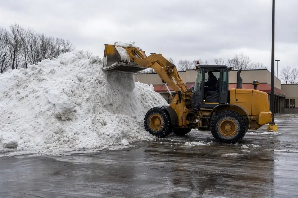 Wheel loader stacking snow in the corner of a parking lot