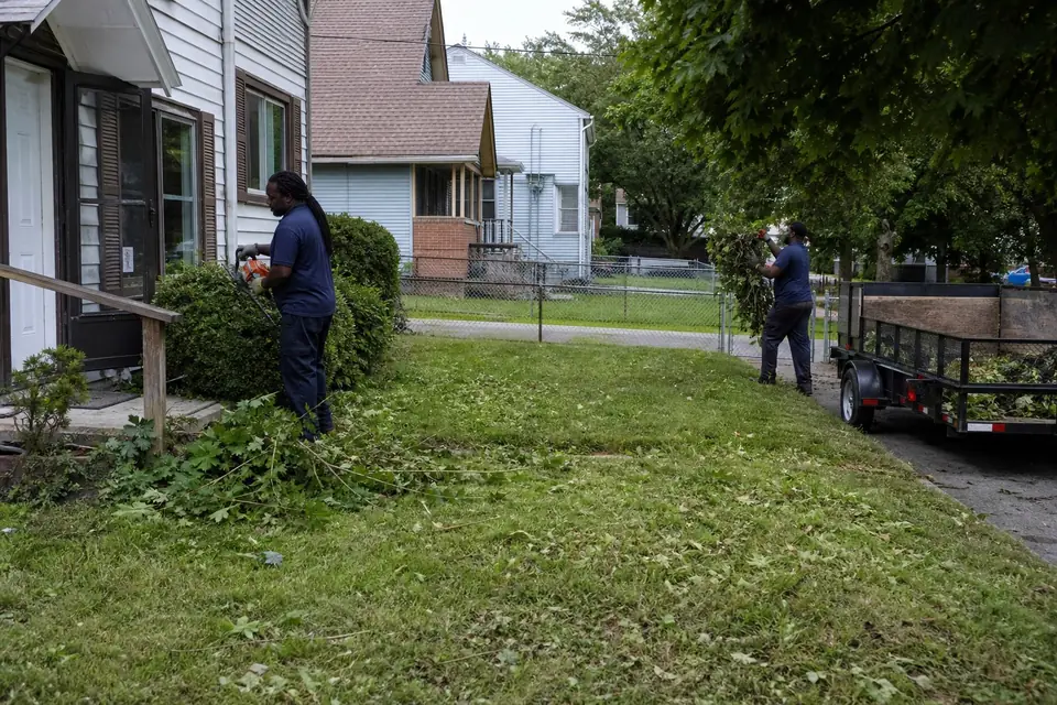 Crew cleaning up overgrown beds at a duplex