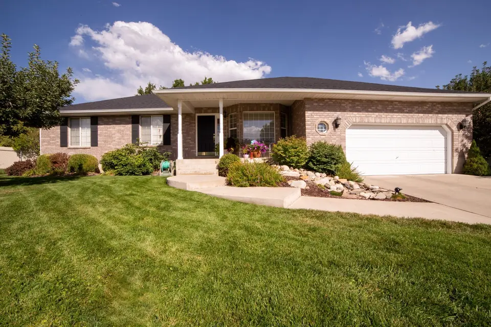 Brick ranch home with a freshly mowed striped lawn and trimmed beds